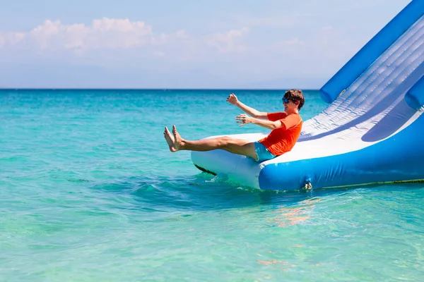 Kinderen Springen Trampoline Tropisch Zeestrand Kinderen Springen Opblaasbare Waterglijbaan Aquapark — Stockfoto