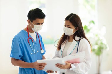 Steteskop ve maske takan Asyalı doktor ya da hemşire. Asya 'daki koronavirüs salgınında uzman. Virüs salgını. Hastane ve klinik personeli. Hastalığı önleme. Sağlık bakımı uzmanı.