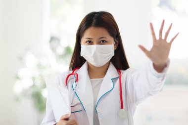 Steteskop ve maske takan Asyalı doktor ya da hemşire. Asya 'daki koronavirüs salgınında uzman. Virüs salgını. Hastane ve klinik personeli. Hastalığı önleme. Sağlık bakımı uzmanı.
