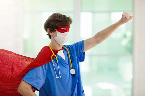 Doctor or nurse wearing surgical face mask in superhero cape. Medical staff during coronavirus outbreak. Super hero power for clinic and hospital personal.