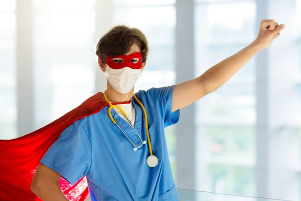 Doctor or nurse wearing surgical face mask in superhero cape. Medical staff during coronavirus outbreak. Super hero power for clinic and hospital personal.