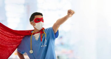 Süper kahraman peleriniyle cerrahi maske takan Asyalı doktor ya da hemşire. Asya 'daki koronavirüs salgını sırasında tıbbi personel. Klinik ve hastane için süper kahraman gücü.