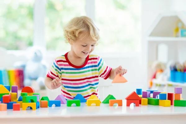 カラフルなおもちゃのブロックで遊んでいる子供 ブロックのおもちゃの小さな男の子の建物の塔 子供のための教育的で創造的なおもちゃやゲーム 虹レンガ付きの白い寝室の赤ちゃん 家にいる子供 — ストック写真