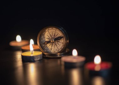 Sesion con velas brujula y mapa en fondo negro