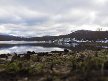 Arkasında karlı dağlar olan bir gölde gün batımı