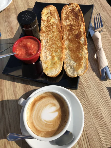 a coffee and some toast with tomato oil and salt