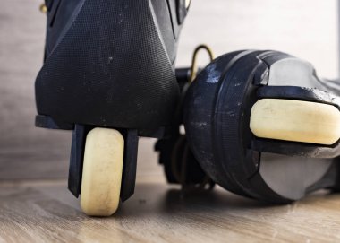 Ahşap zeminde altın bağcıklı siyah paten fotoğrafları.