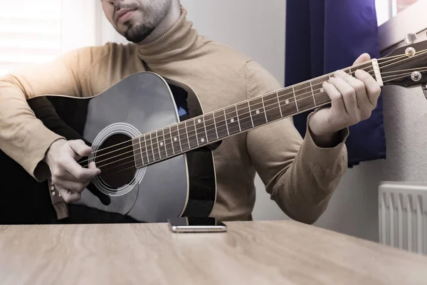 Acoustic guitarist playing. Musical instrument with executable hands.