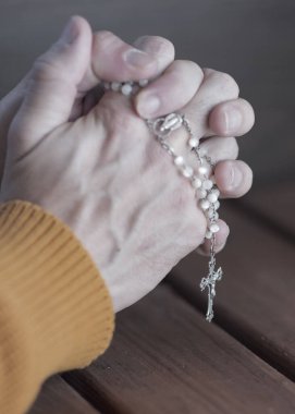 Tahta arka planda bir tespihle dua etmek, salgın korkusu