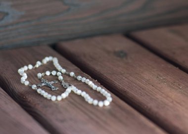 Tahta arka planda bir tespihle dua etmek, salgın korkusu