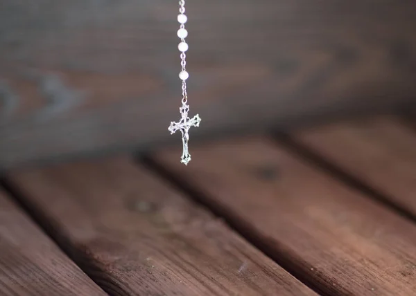 Praying with a rosary on wooden background, fear of pandemic