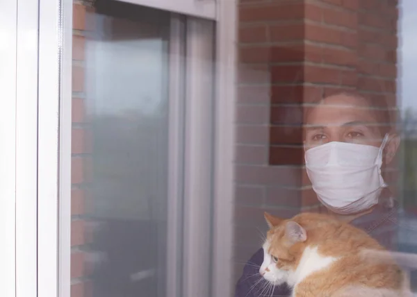 科罗纳病毒头戴皇冠病毒的病人从窗户向外张望 戴着防护面具 在家中从病痛中恢复过来 Covid 19的自绝缘 — 图库照片
