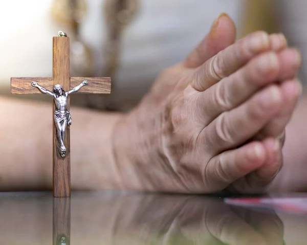praying hands next to a wooden cross, easter
