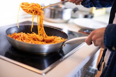 Genç adam mutfakta yemek pişiriyor. Ev aşçısı mükemmel bir yemek hazırlıyor..