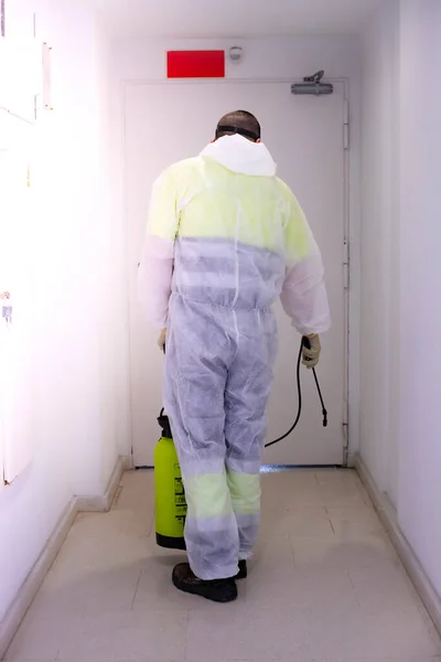 太陽の公共の場所を化学物質で消毒して コロナウイルスの拡散 隔離都市のパンデミックを防ぐためにスプレーする保護スーツを身に着けている人 Covid 清掃コンセプト — ストック写真