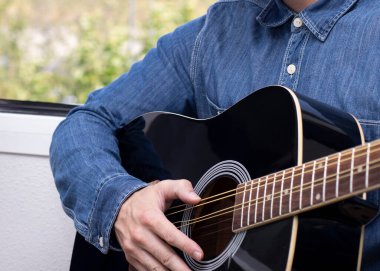 Gitar dersleri ya da gitar arkasından çalınan iki müzisyen.