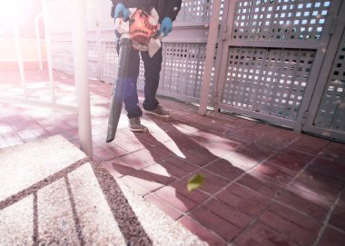 Sokakta çalışan bir işçi Yaprak üfleyicisi olan bir adam