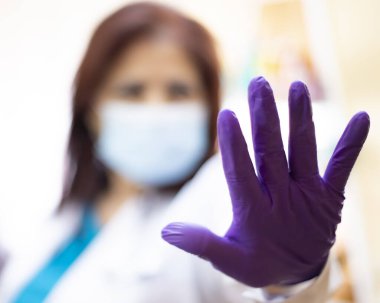 Eldivenli doktor, açık el, sosyal mesafeli covid-19.