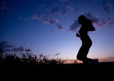 Gün batımında koşan atletler. günbatımı bulutları