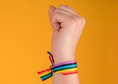 El yapımı gökkuşağı bileziği, LGBT, gay gururu, pastel sarısı arka planda