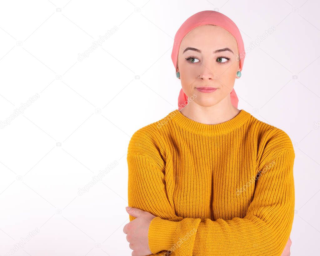 woman with pink scarf with cancer, worried with arms crossed