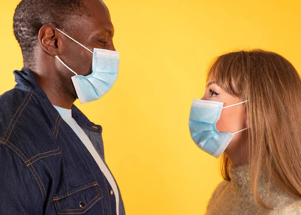 two people with protective masks on light background. Epidemic concept
