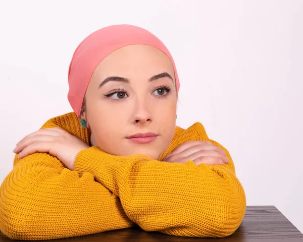 woman with cancer wearing a thoughtful pink scarf