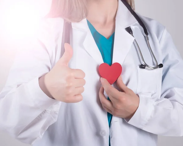 medical woman holding a red heart, on white background