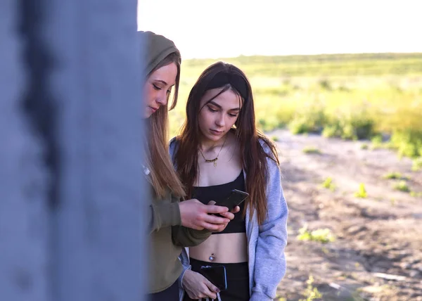 Retrato Dos Mujeres Adolescentes Que Miran Entre Tienen Teléfonos Móviles —  Fotos de Stock