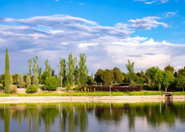 Göl kenarına park, bulutlu güneşli bir gün.
