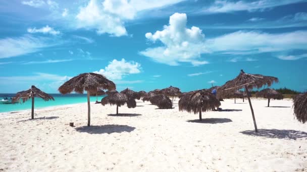 Esernyők a a fehér homokos strand, Cayo Largo, Kuba. Azúrkék víz és fehér homok. — Stock videók