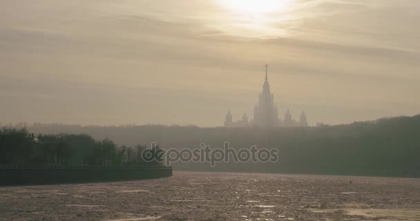 Frozen Moscow river and building of Moscow State University in the rays of the winter sun time-lapse — Stock Video