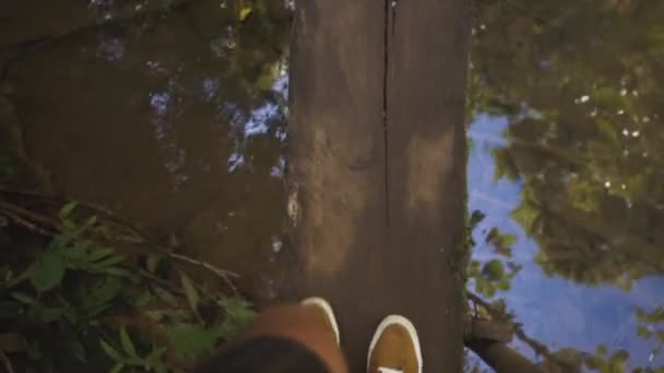 腿的人走在一座小木桥，从上面查看. — 图库视频影像