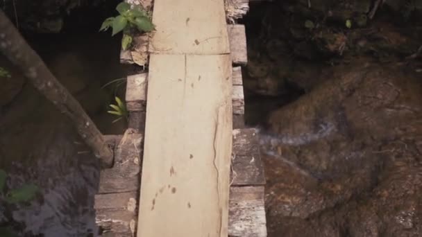 Piernas hombre caminando sobre un puente de madera, vista desde arriba . — Vídeos de Stock