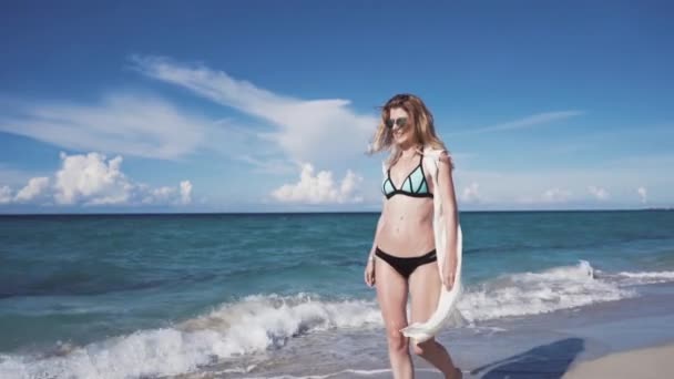 Счастливая красивая блондинка идет по пляжу — стоковое видео