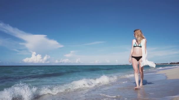 Η όμορφη ξανθιά σε ένα μπικίνι περπάτημα στην παραλία — Αρχείο Βίντεο