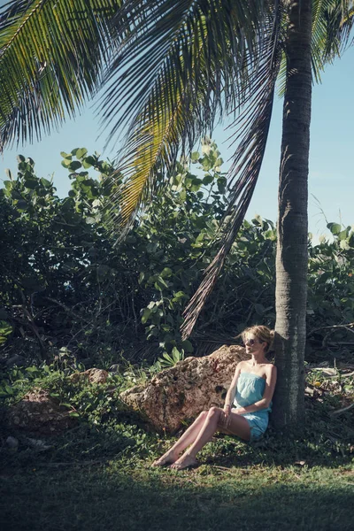 Az általános terv a lány ül a kövön kötekedik a fák és a szél áramló haj. — Stock Fotó
