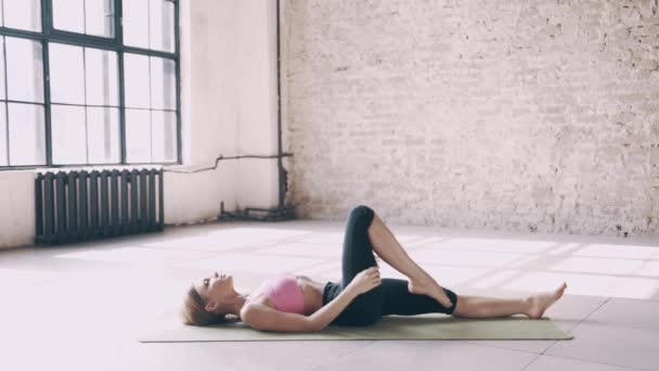 Schöne Yoga-Mädchen tun Asanas im Studio — Stockvideo