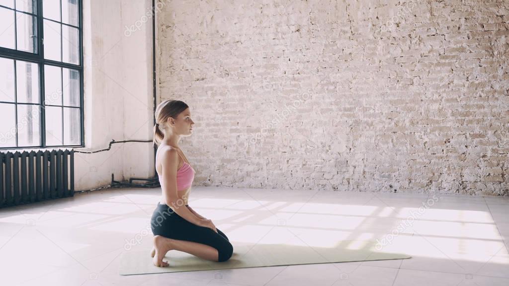Beautiful yoga girl doing asanas in studio