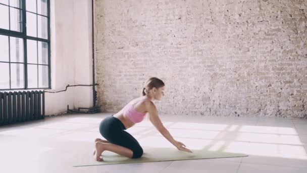Красивая девушка-йога делает асаны в студии — стоковое видео