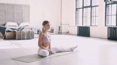 Evde yoga. Pembe spor giysileri bir kızı evde asanas yapar.