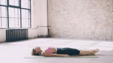 Yoga egzersizleri yalan ve mindere oturmuş.