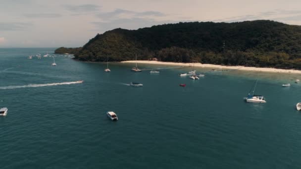 Tailandia Coral Island Drone Shot Pequeños barcos deportivos, grandes catamaranes, goletas de pesca, tráfico activo cerca de la isla para el entretenimiento de los turistas . — Vídeo de stock