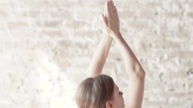 Yogi kız büyük parlak odanın ortasında egzersizleri yapıyor.