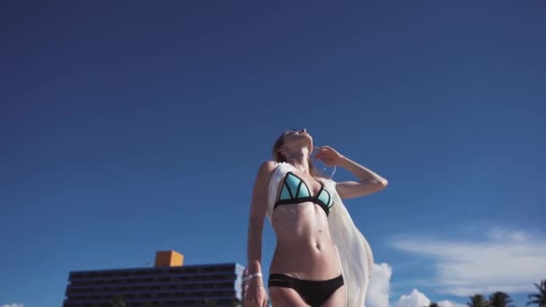 Meisje in bikini op een achtergrond van de blauwe hemel — Stockvideo