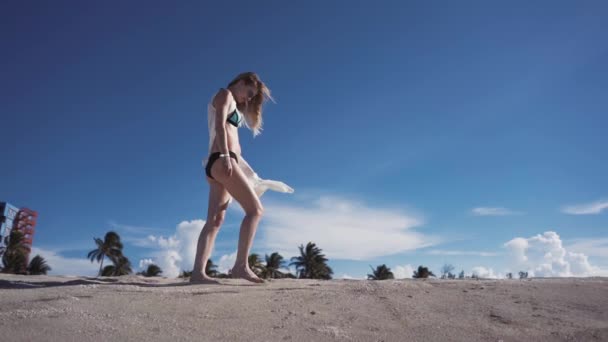 Девушка, пляж, море, ветер в волосах, девушка в бикини, идущая вдоль пляжа с песком — стоковое видео