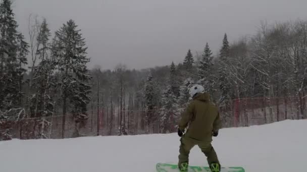 Der Snowboarder fährt mit hoher Geschwindigkeit den Hang hinunter — Stockvideo