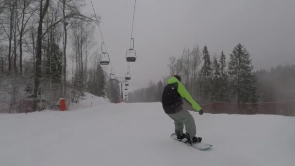 Der Snowboarder fährt mit hoher Geschwindigkeit den Hang hinunter — Stockvideo