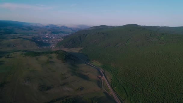 AERIAL, TOP LETÖLTÉS: Sötét színű autó halad le egy aszfalt úton átszeli a hatalmas erdő egy napsütéses nyári napon. — Stock videók