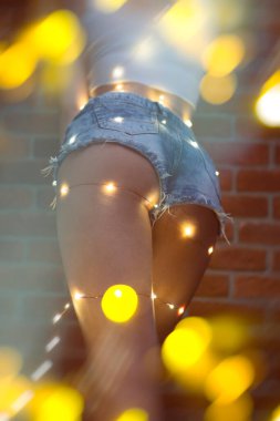 Güzel genç kadın gülümseyerek ve şehir ışıkları çelenk sokak konuşuyor